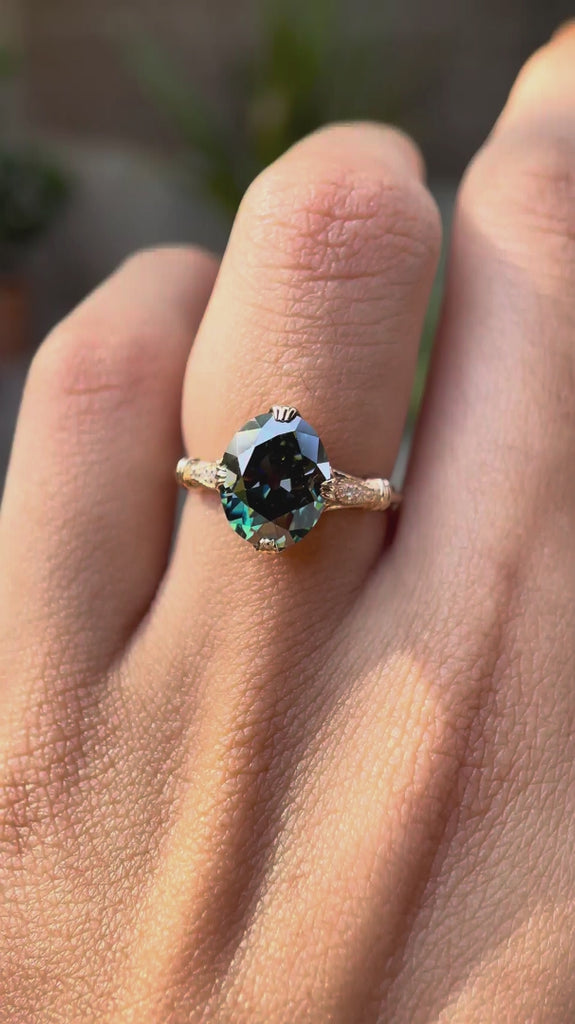 Rotating view of blue green oval moissanite cathedral ring worn on hand