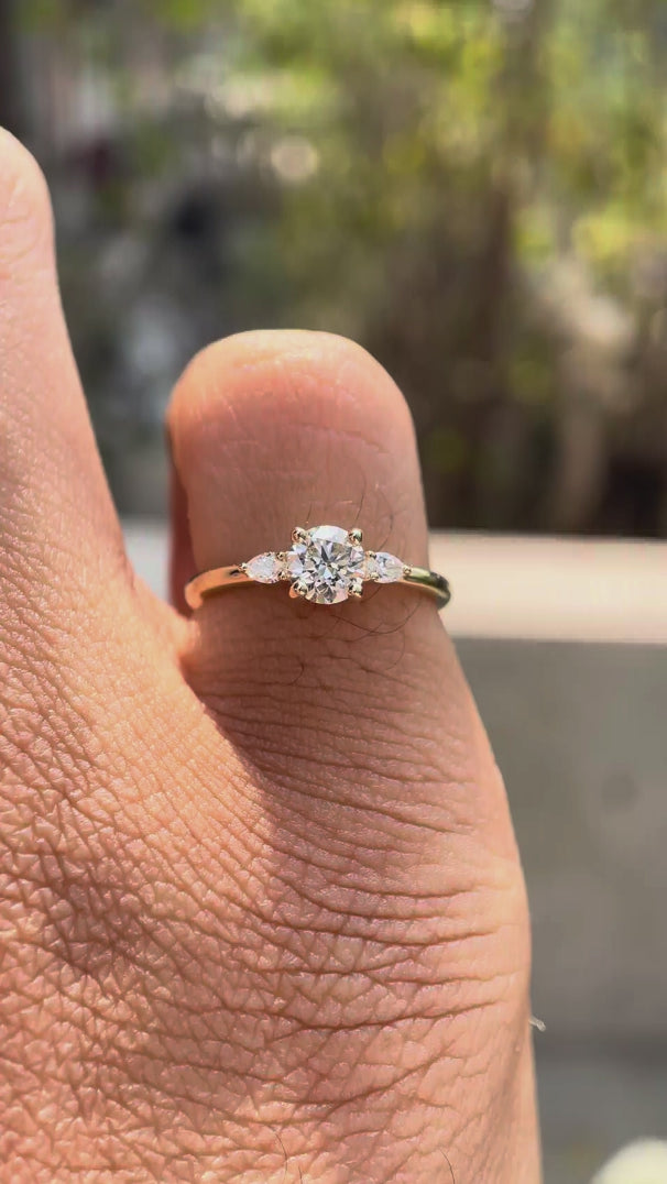 Rotating video of round cut lab grown diamond three stone ring in 14K yellow gold showing prong setting and band profile
