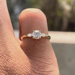 Rotating video of round cut lab grown diamond three stone ring in 14K yellow gold showing prong setting and band profile