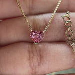 Video view of pink heart diamond pendant on chain sparkling in hand