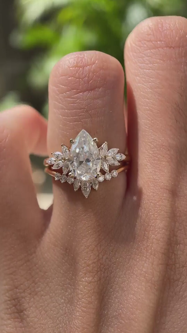Close rotating view of pear moissanite ring with curved stacking band