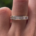 Close up view of channel set baguette moissanite eternity band worn on finger