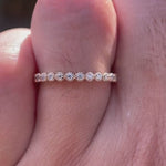 Close up video of half eternity Art Deco bezel set moissanite wedding band