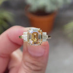 360-degree view of emerald cut champagne ring with side baguettes