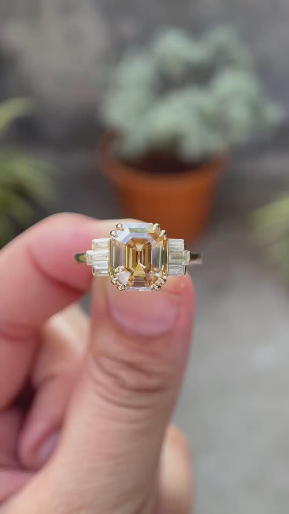360-degree view of emerald cut champagne ring with side baguettes