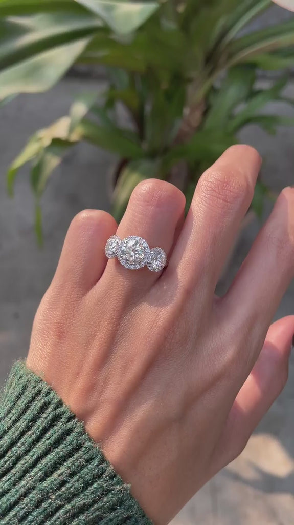 Elegant three stone round halo ring worn on hand video