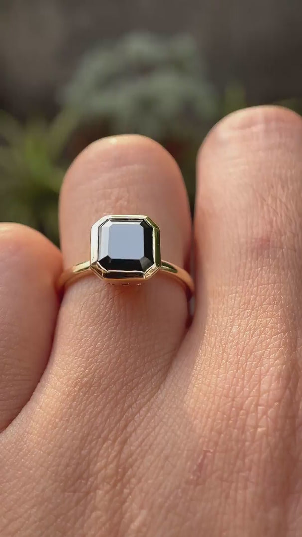 Asscher cut dark green moissanite bezel set solitaire ring rotating view showcasing side profile and brilliance