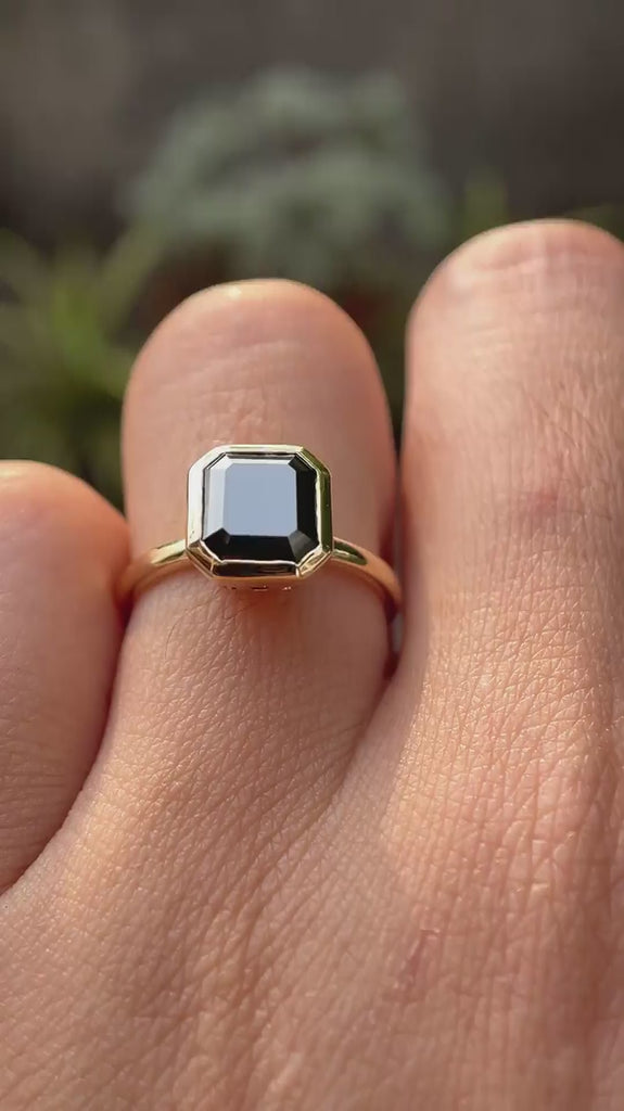 Asscher cut dark green moissanite bezel set solitaire ring rotating view showcasing side profile and brilliance