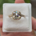 A close-up view of the Bezel Set Cushion Cut Moissanite Engagement Ring in 14K Yellow Gold, highlighting the 3 CT Moissanite center stone and round side stones, showcasing the ring from multiple angles.
