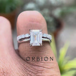 Emerald cut moissanite hidden halo ring rotating view highlighting hidden halo and pavé band brilliance