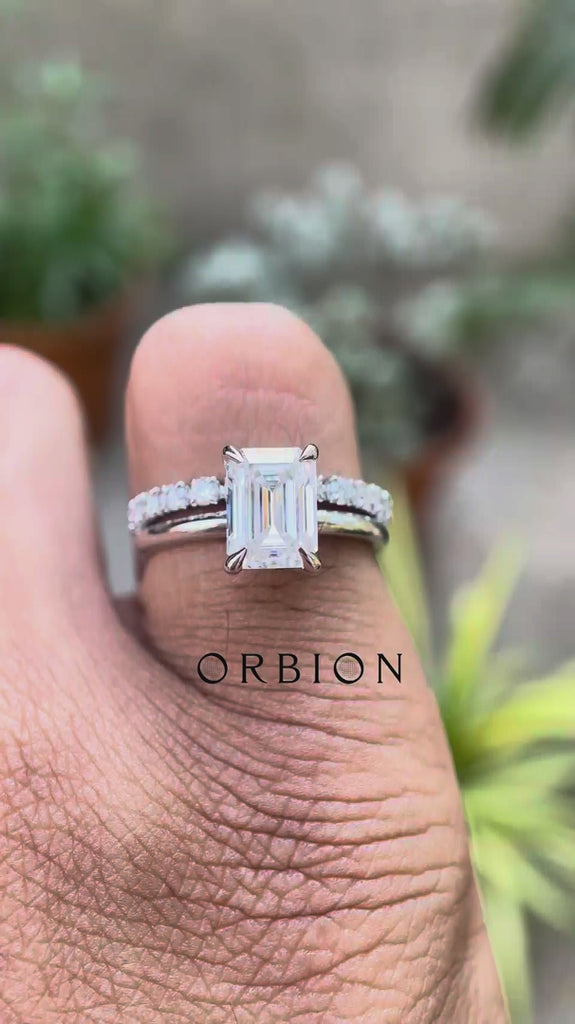 Emerald cut moissanite hidden halo ring rotating view highlighting hidden halo and pavé band brilliance