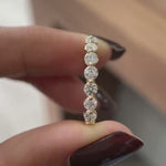 Close rotating view of round lab diamond shared prong half eternity band
