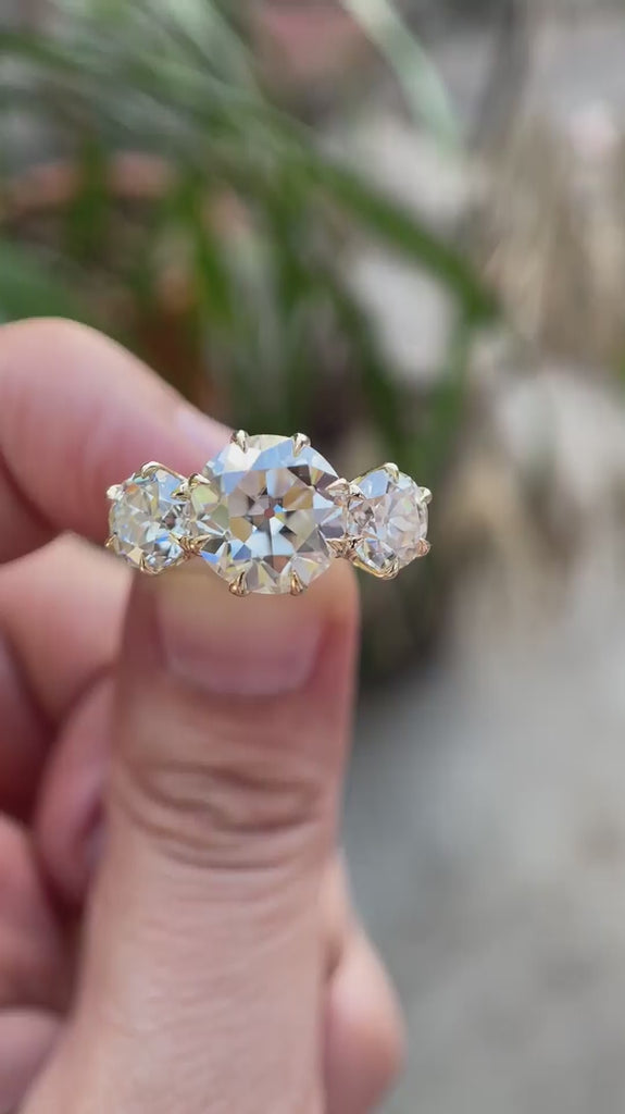 Three stone Old European cut moissanite ring rotating view in yellow gold