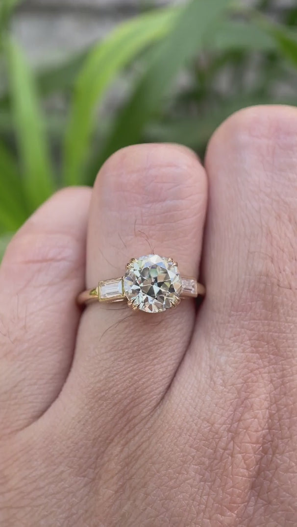 Moissanite three-stone round Old European cut engagement ring with baguette side stones, displayed in a video showcasing the ring from different angles.