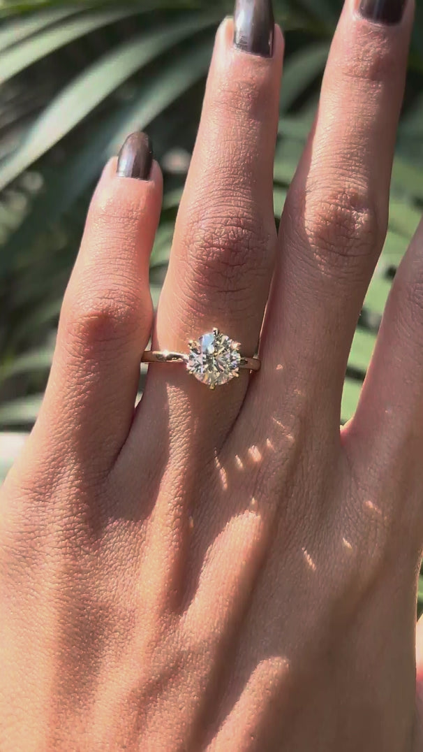 Rotating view round lab diamond twisted solitaire ring in yellow gold.
