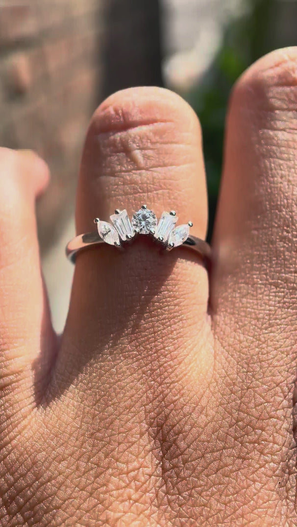 Rotating view of curved multi stone moissanite band in white gold