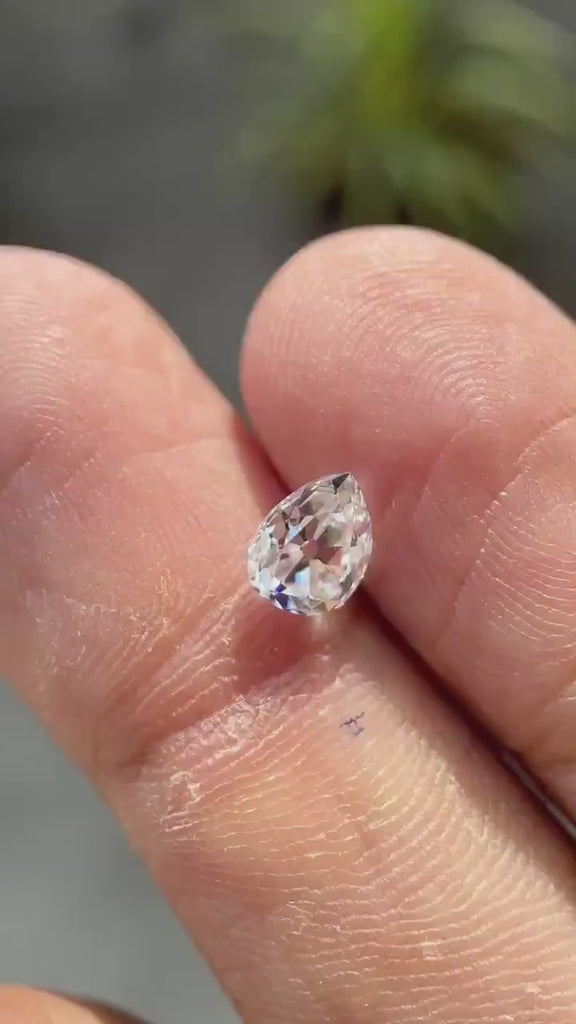 Pear old mine cut white moissanite showing sparkle