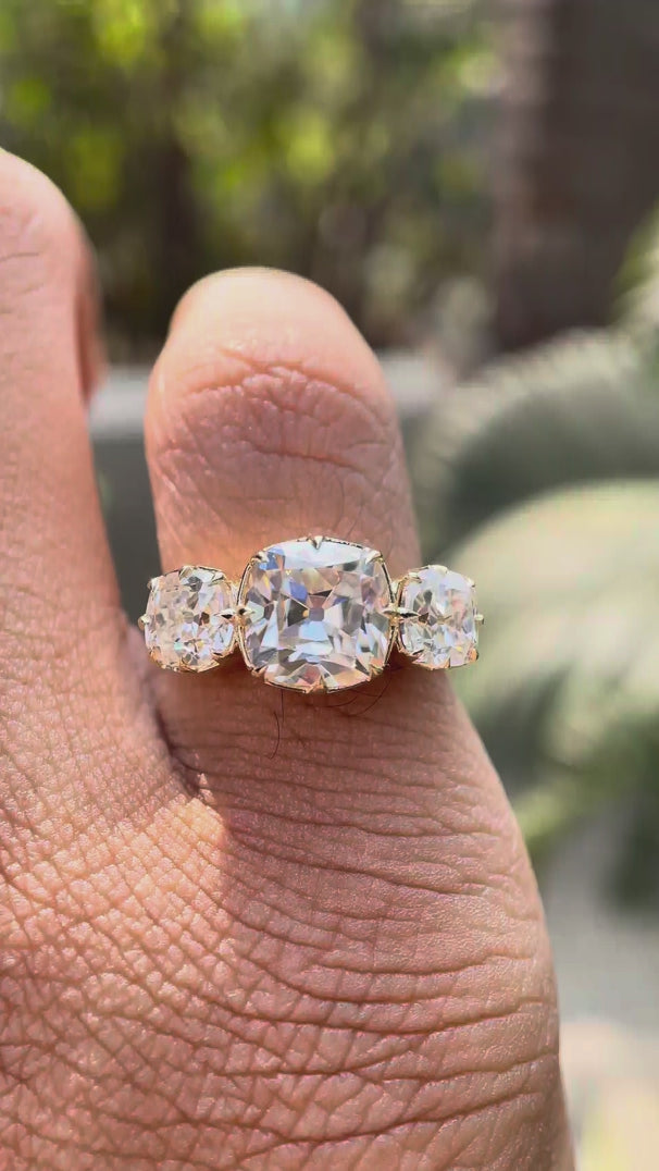 Hand worn three stone square cushion Old Mine cut moissanite ring showing sparkle and side profile in natural lighting