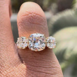 Hand worn three stone square cushion Old Mine cut moissanite ring showing sparkle and side profile in natural lighting