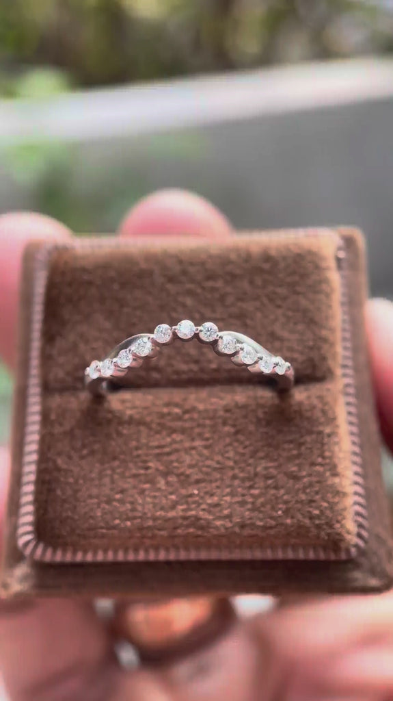 Rotating view of curved bubble prong half eternity wedding band in matte white gold