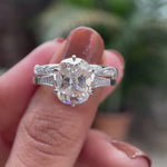 Moissanite engagement ring featuring an elongated cushion center stone with side stones, displayed in a detailed video