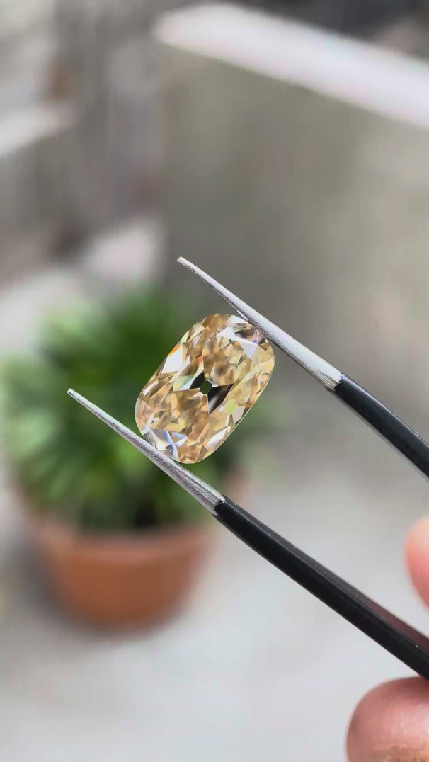 Elongated cushion light champagne moissanite Old Mine Cut rotating view showcasing facet brilliance