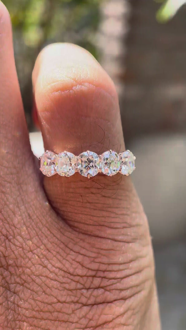Rotating video showing five elongated cushion moissanites in rose gold band