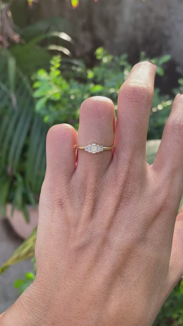 Rotating video showing bar set five stone baguette moissanite gold ring.