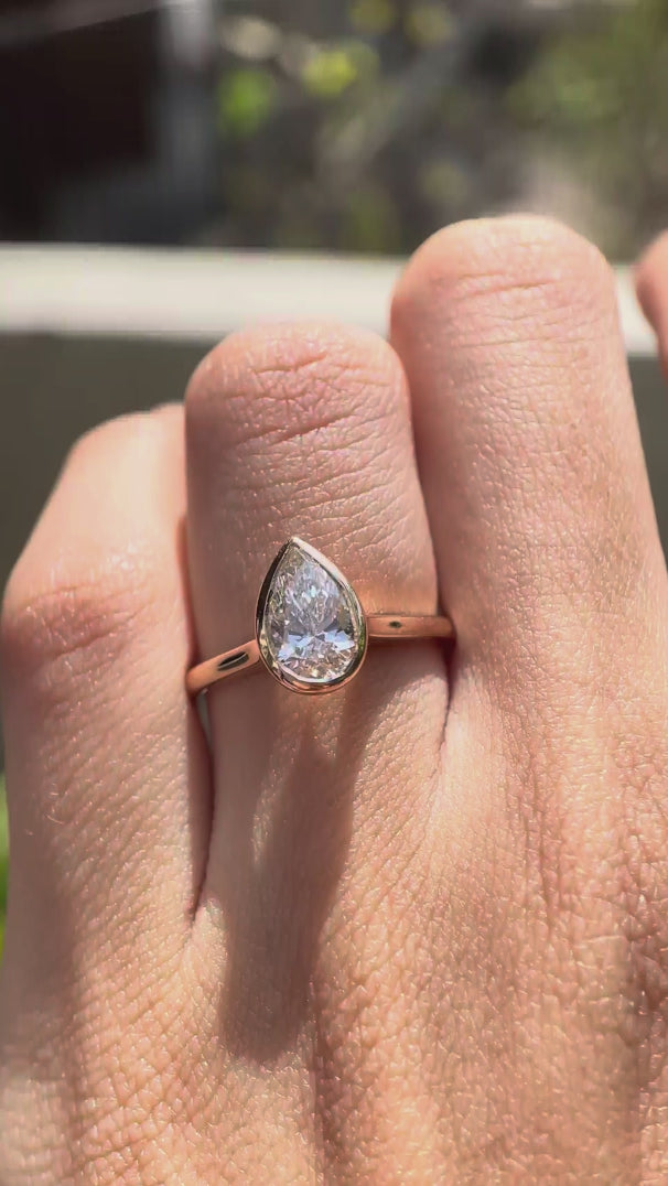 Rotating video of pear cut lab grown diamond bezel cathedral solitaire ring in rose gold