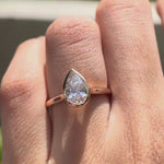 Rotating video of pear cut lab grown diamond bezel cathedral solitaire ring in rose gold