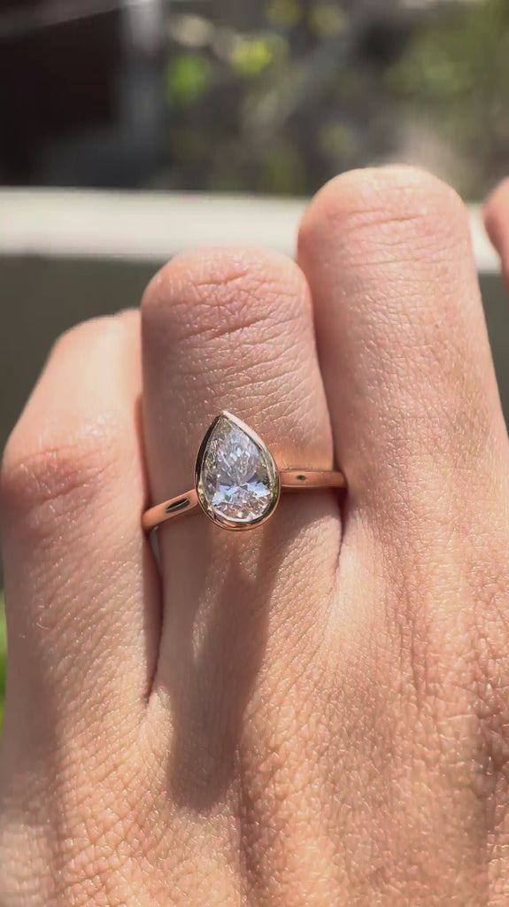 Rotating video of pear cut lab grown diamond bezel cathedral solitaire ring in rose gold