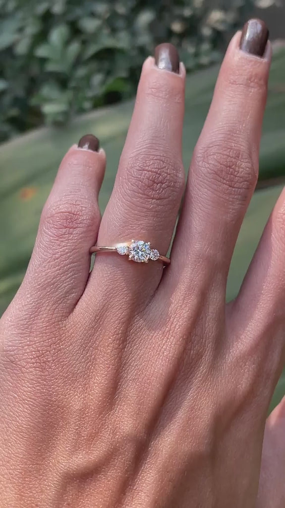 Delicate three stone engagement ring on hand yellow gold video