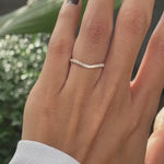 Close rotating view of unique moissanite curved wedding band in yellow gold