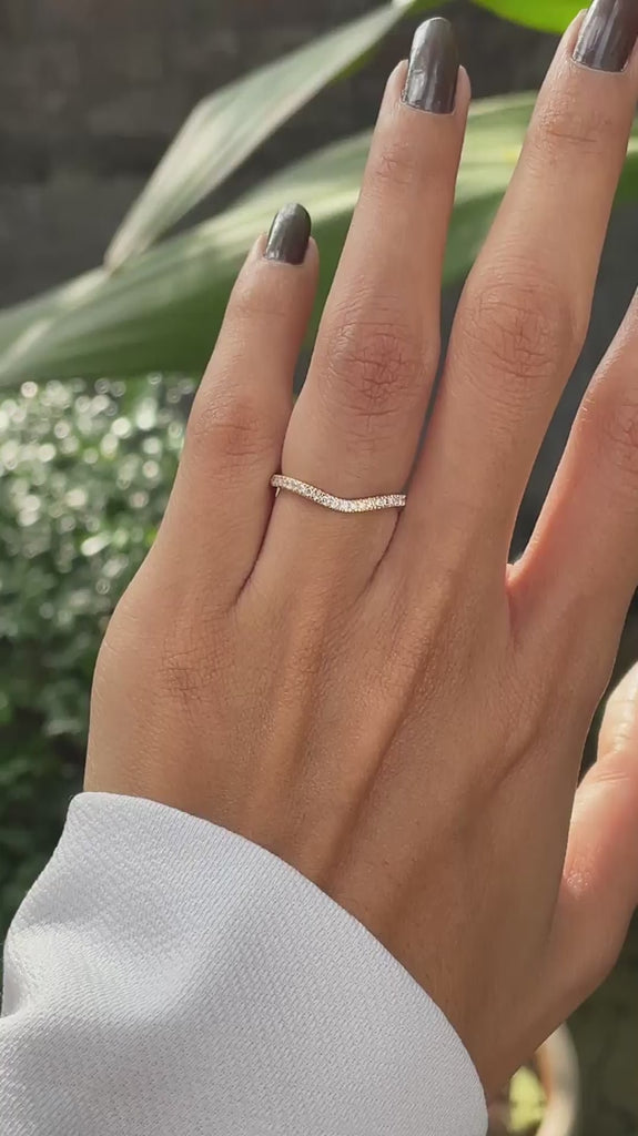 Close rotating view of unique moissanite curved wedding band in yellow gold