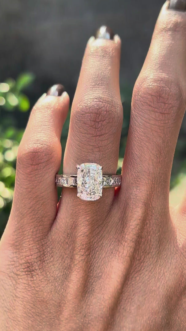 Rotating view elongated cushion lab diamond ring with channel set band.