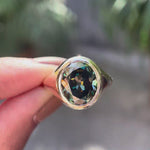 Oval blue green moissanite signet ring shown in rotating video