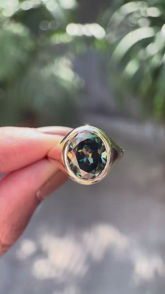 Oval blue green moissanite signet ring shown in rotating video