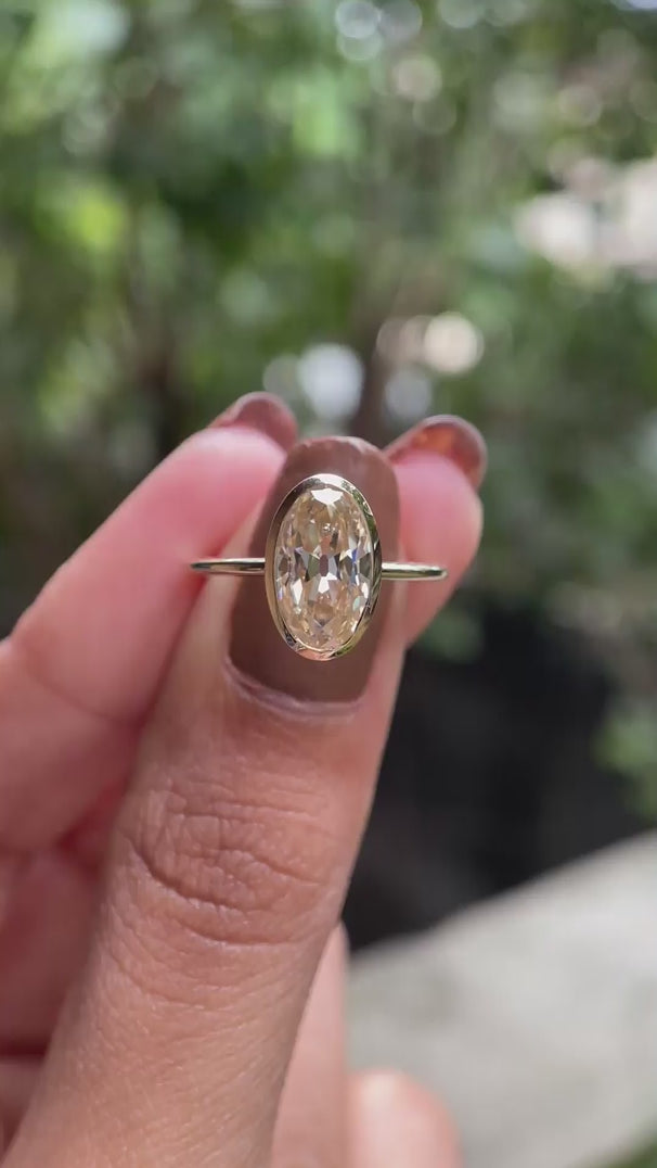 Rotating oval champagne bezel ring  showing side profile and sparkle