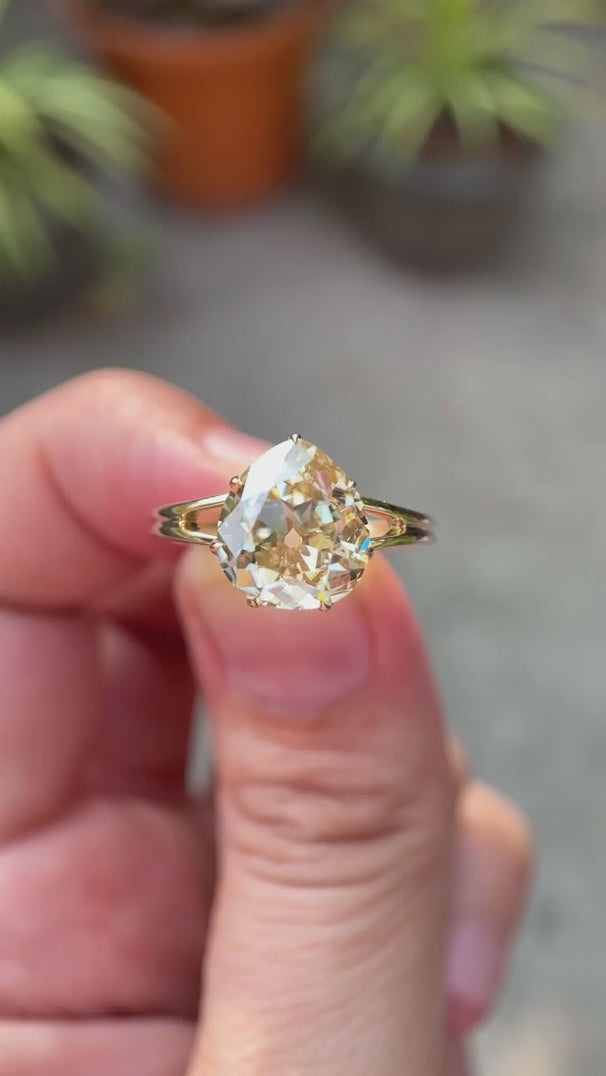Pear old mine cut light champagne moissanite split shank solitaire engagement ring in 10K yellow gold shown in rotating video