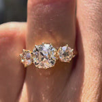Rotating video showcasing vintage three-stone ring worn on finger in yellow gold.
