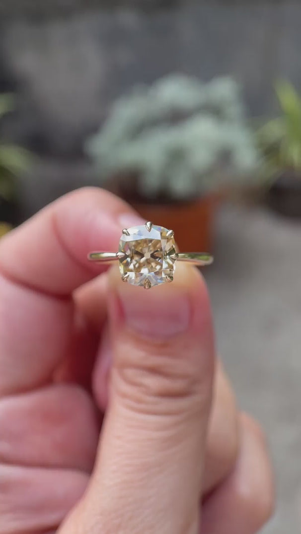Elongated cushion old mine cut light champagne moissanite solitaire ring in 10K yellow gold rotating view