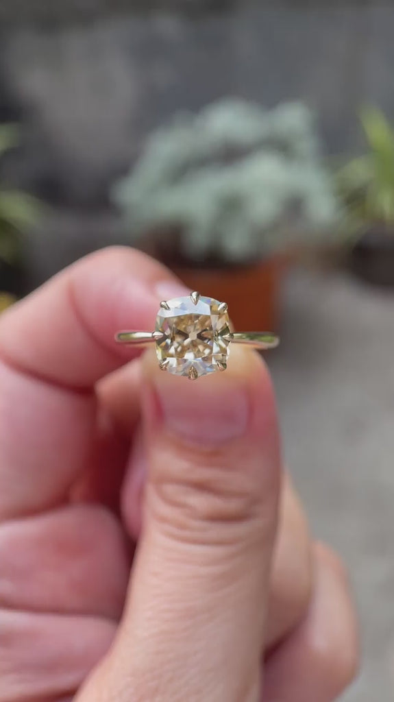 Elongated cushion old mine cut light champagne moissanite solitaire ring in 10K yellow gold rotating view