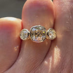 Three stone Old Mine cushion champagne moissanite ring in 10K yellow gold rotating view