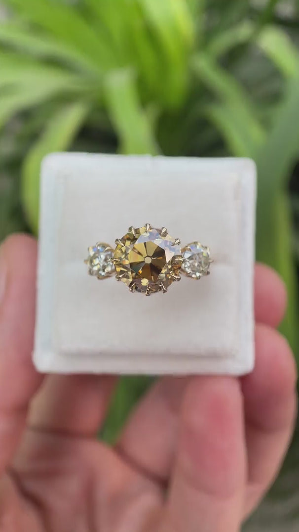 Round Old European cut light champagne moissanite three stone ring in 10K yellow gold rotating view