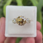 Round Old European cut light champagne moissanite three stone ring in 10K yellow gold rotating view