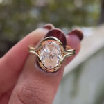 Rotating close-up video showcasing oval solitaire half bezel floating engagement ring