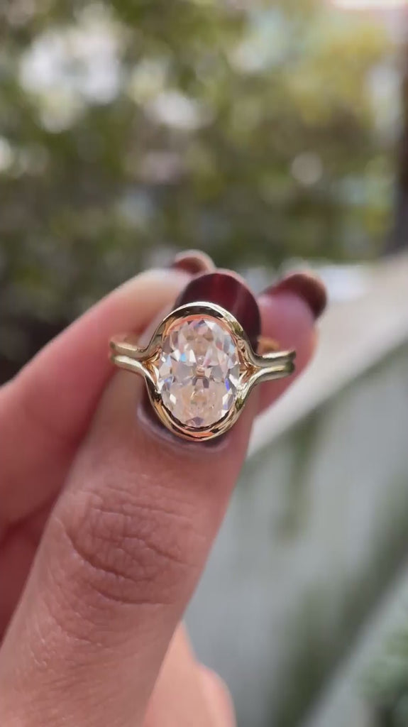 Rotating close-up video showcasing oval solitaire half bezel floating engagement ring