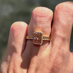 Nature inspired pink diamond engagement ring featuring intricate leaf engraving and bezel setting in 18k yellow gold