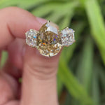 Pear old mine cut light champagne moissanite three stone ring rotating view