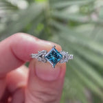Video showcasing princess cut fancy vivid blue lab grown diamond cluster engagement ring with moissanite accents in 14K white gold